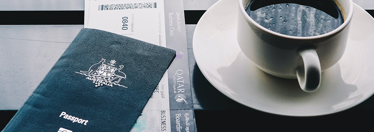 A close up of a passport and cup of coffee.