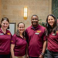 Four ISSS staff wearing maroon ISSS polos
