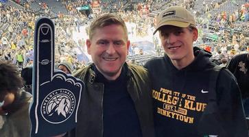 Bolli at a Timberwolves game with another person wearing a Timberwolves foam finger