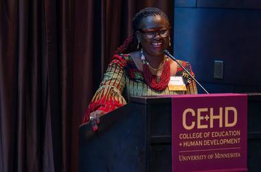 Millicent Adjei speaking behind a podium